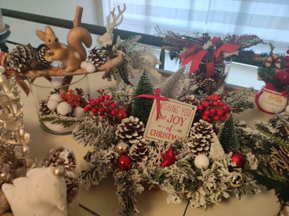 A christmas arrangement with pine cones and red and white decorations
Description automatically generated