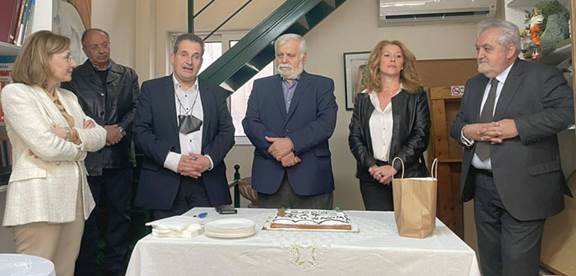 A group of people standing in front of a table
AI-generated content may be incorrect.